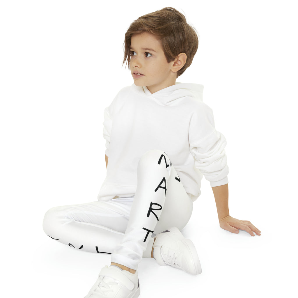 A boy sitting cross-legged while wearing white leggings with a picture of a turtle on the front left waist and the phrase "I am smart" read top to bottom on the side of each leg.