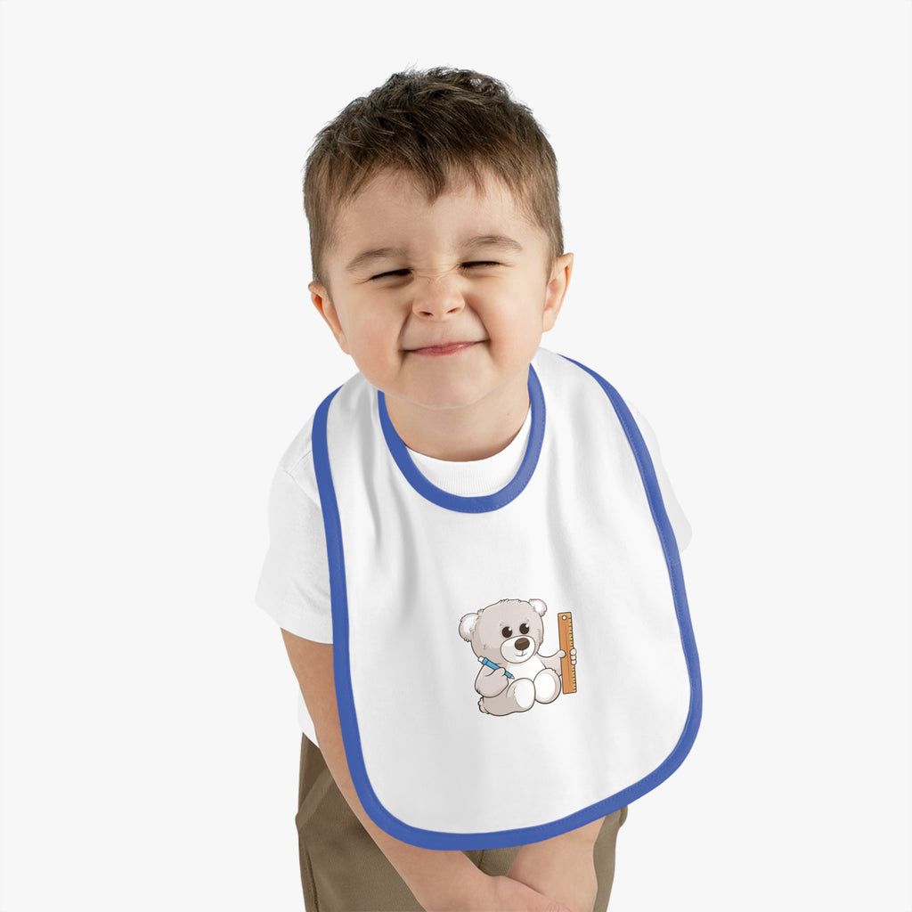 A little boy wearing a white baby bib with royal blue trim and a small picture of a bear.