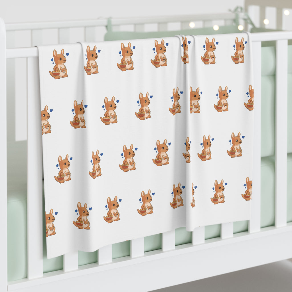 A white swaddle blanket with a repeating pattern of a kangaroo. The blanket is draped over the side of a baby crib.