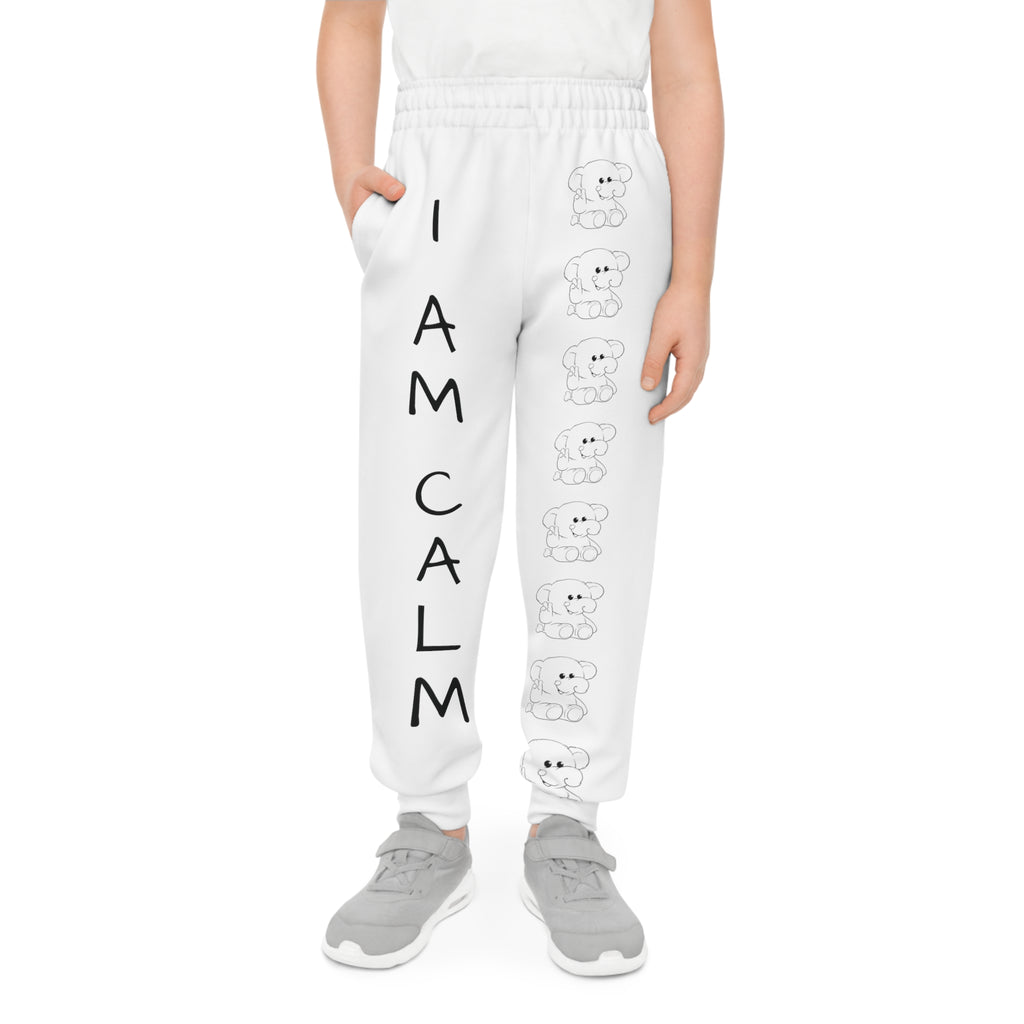 Front-view of a boy wearing white sweatpants with a line of black and white elephants down the front left leg and the phrase "I am calm" down the front right leg.