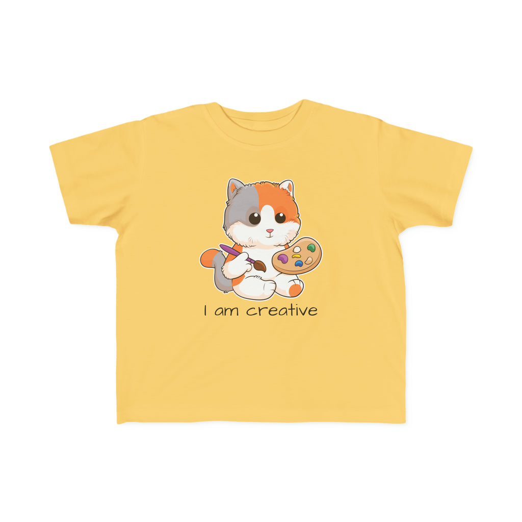 A short-sleeve yellow shirt with a picture of a cat that says I am creative.