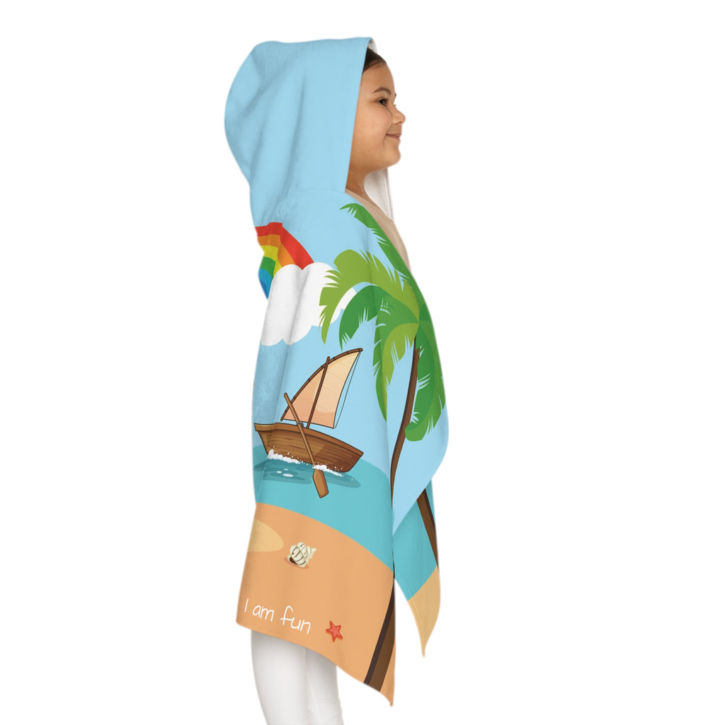 Right side-view of a girl wearing a hooded towel and holding it closed around her. The towel has a scene of a monkey playing volleyball on the beach, a rainbow in the background, and the phrase "I am fun" along the bottom.