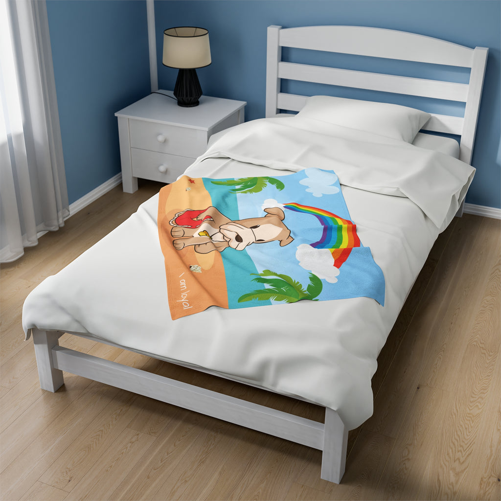A 30 by 40 inch blanket on a twin-sized bed in a bedroom. The blanket has a scene of a dog lifeguard standing on a beach with a rainbow in the background and the phrase "I am loyal" along the bottom.