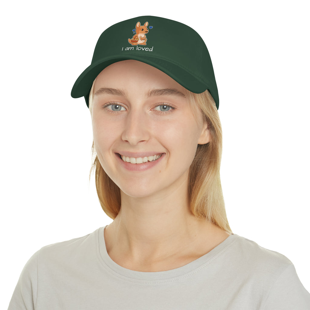 A female wearing a dark green baseball hat with a picture of a kangaroo that says I am loved.