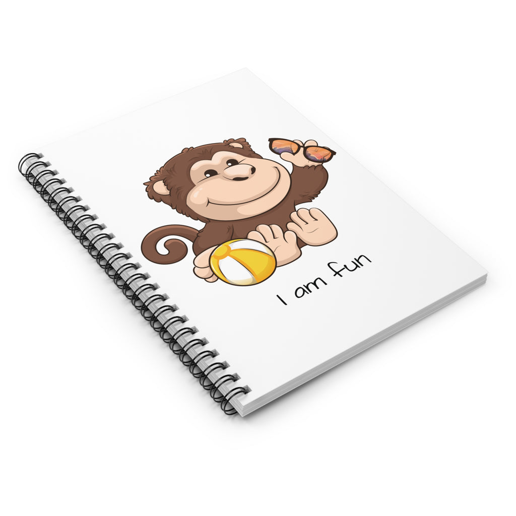 Side-view of a white spiral notebook laying closed, featuring a picture of a monkey that says I am fun.