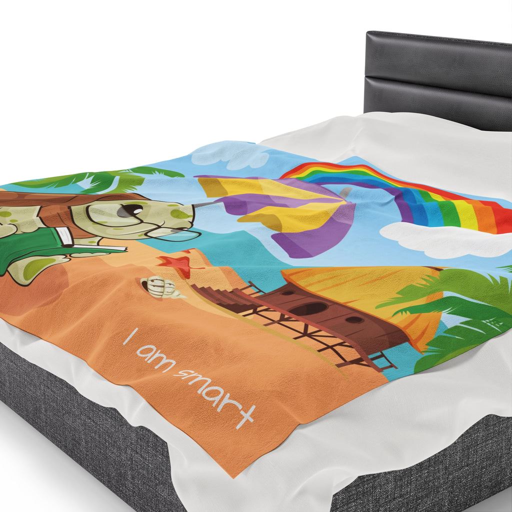 Side-view of a 60 by 80 inch blanket on a queen-sized bed. The blanket has a scene of a turtle reading under an umbrella on the beach, a rainbow in the background, and the phrase "I am smart" along the bottom.
