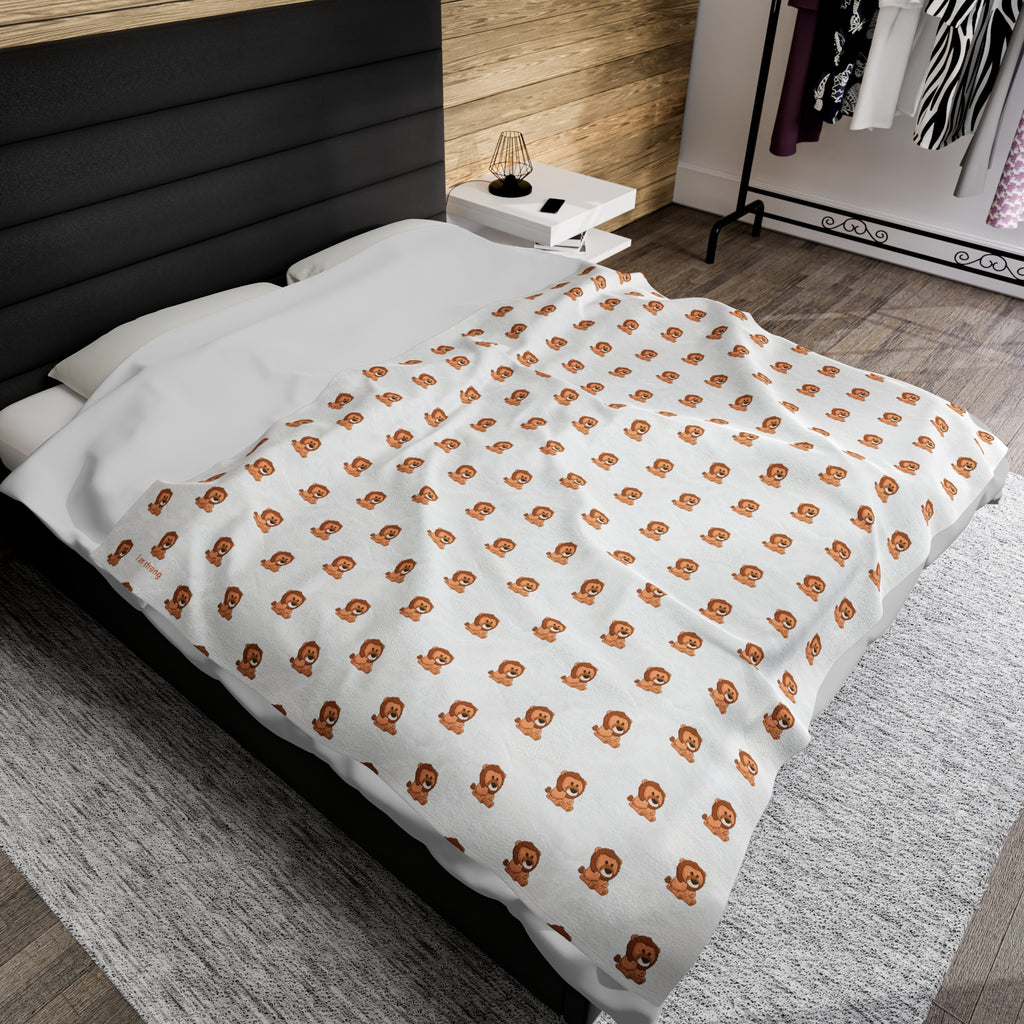A 60 by 80 inch blanket on a queen-sized bed in a bedroom. The blanket has a repeating pattern of a lion and the phrase “I am strong” in the bottom left corner.