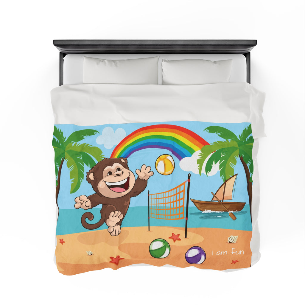 Top-view of a 60 by 80 inch blanket on a queen-sized bed. The blanket has a scene of a monkey playing volleyball on the beach, a rainbow in the background, and the phrase "I am fun" along the bottom.