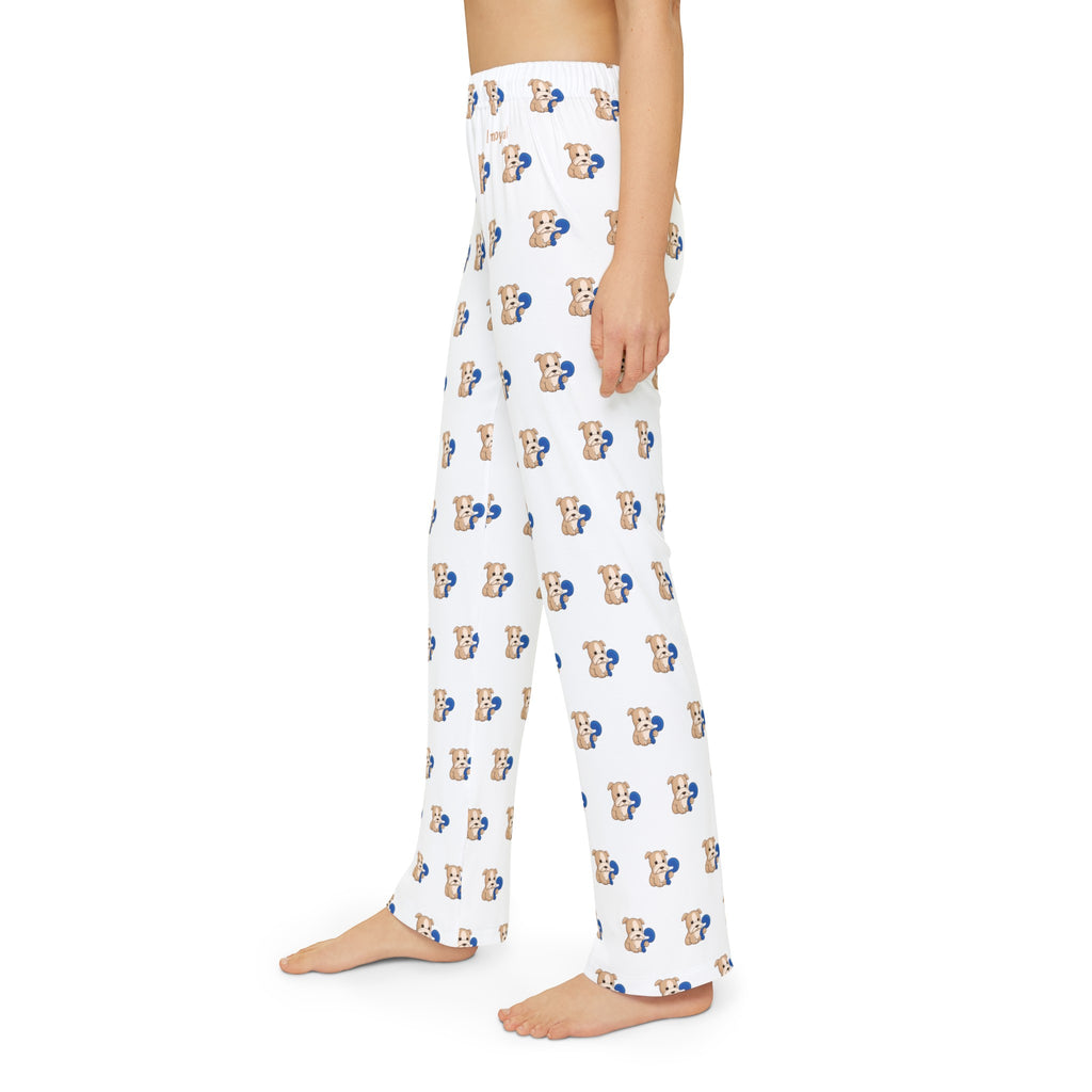 Left side-view of a kid wearing white pajama pants with a repeated pattern of a dog and the phrase “I am loyal” on the front left waist.