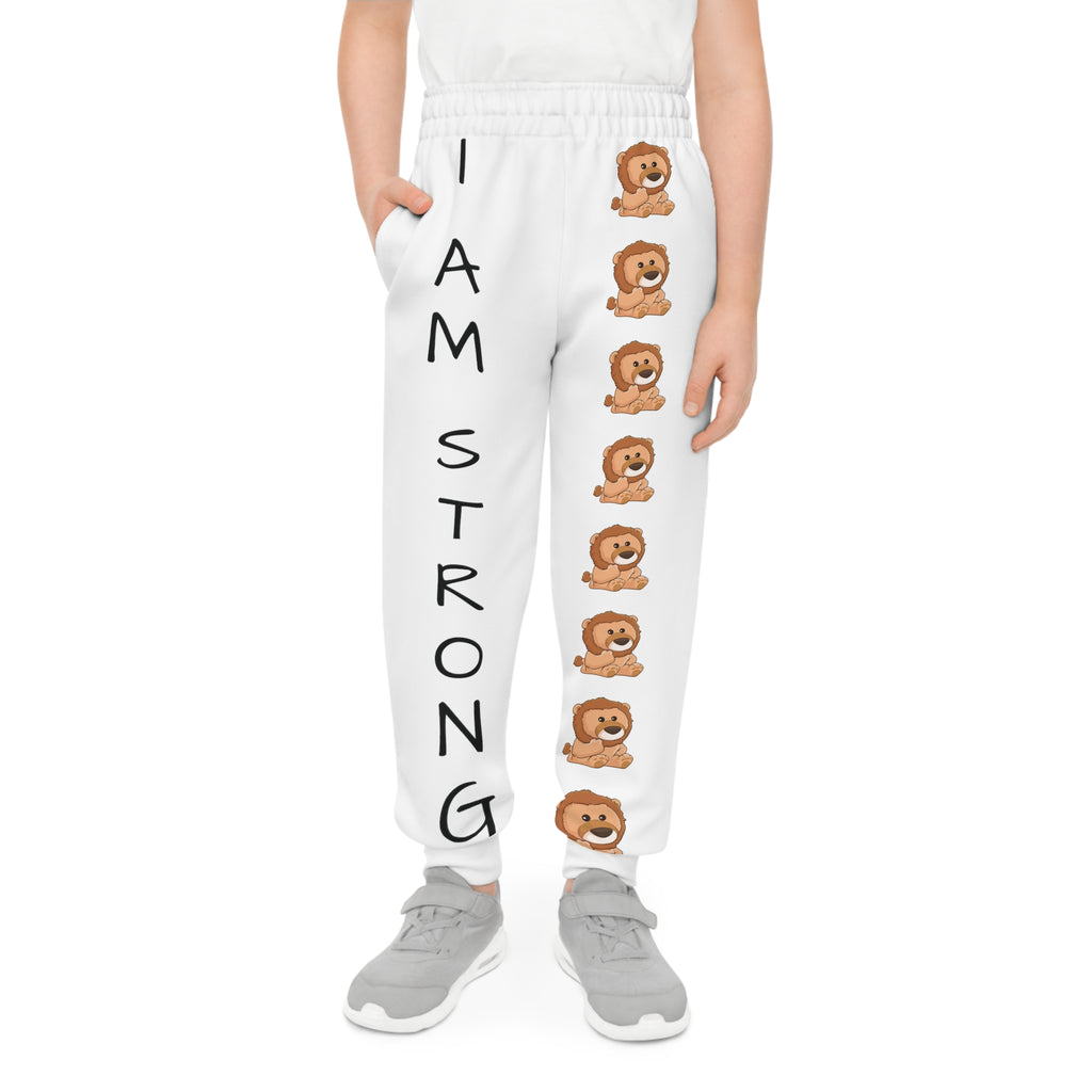 Front-view of a boy wearing white sweatpants with a line of lions down the front left leg and the phrase "I am strong" down the front right leg.