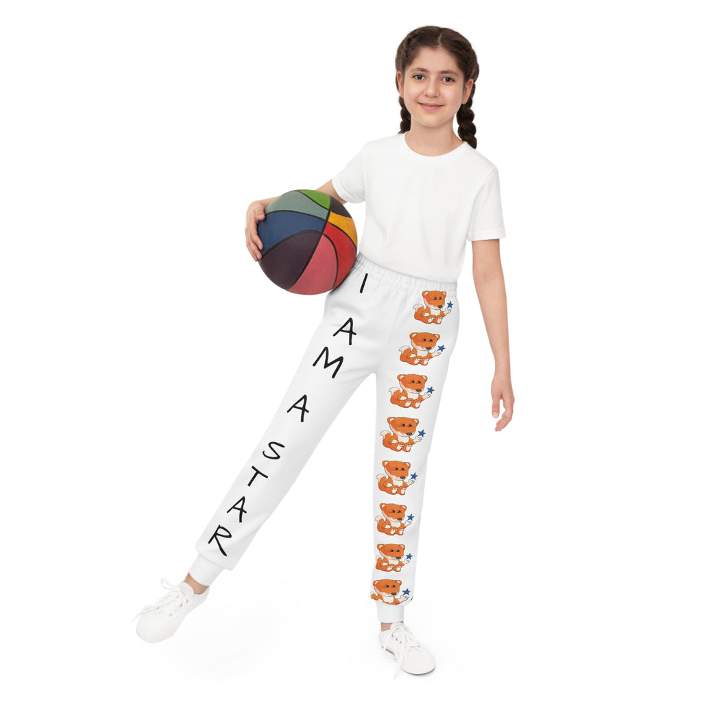 Front-view of a girl holding a basketball and wearing white sweatpants. The pants have a line of foxes down the front left leg and the phrase "I am a star" down the front right leg.