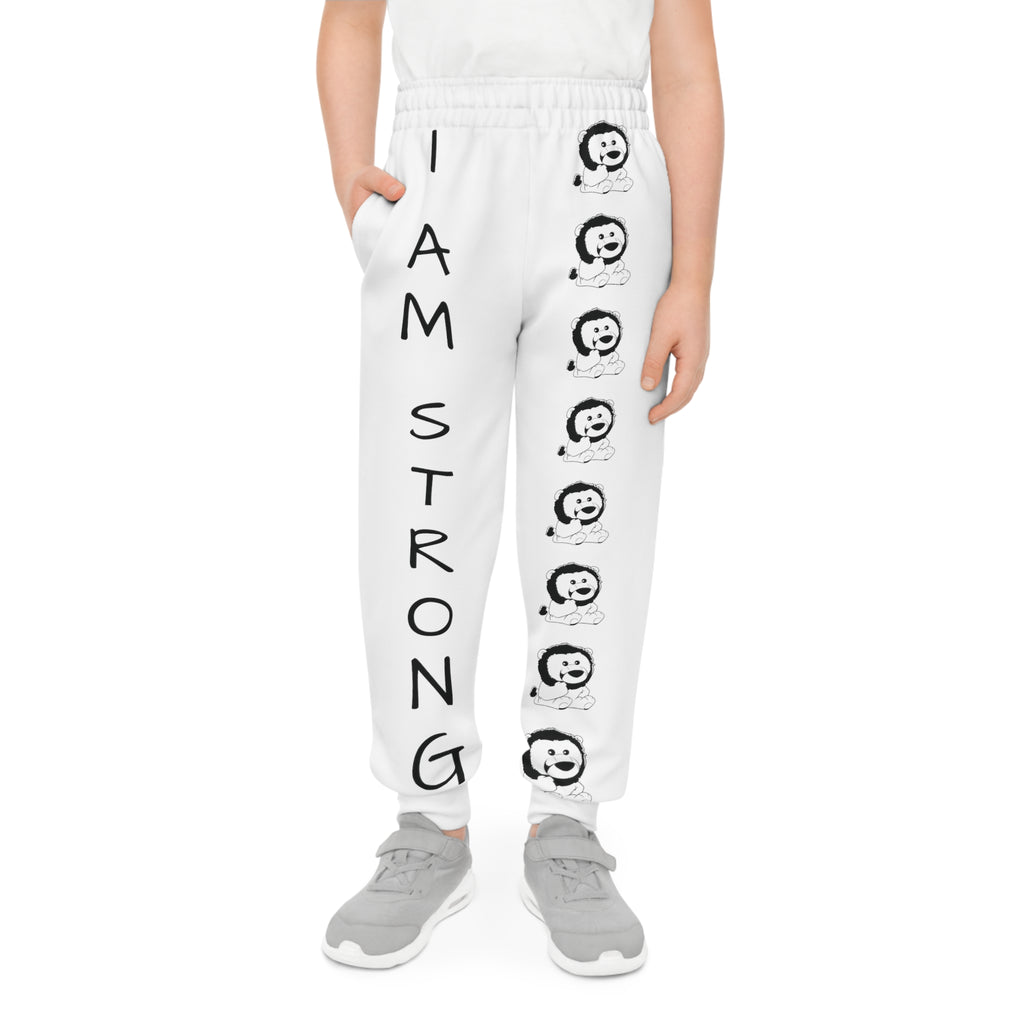 Front-view of a boy wearing white sweatpants with a line of black and white lions down the front left leg and the phrase "I am strong" down the front right leg.