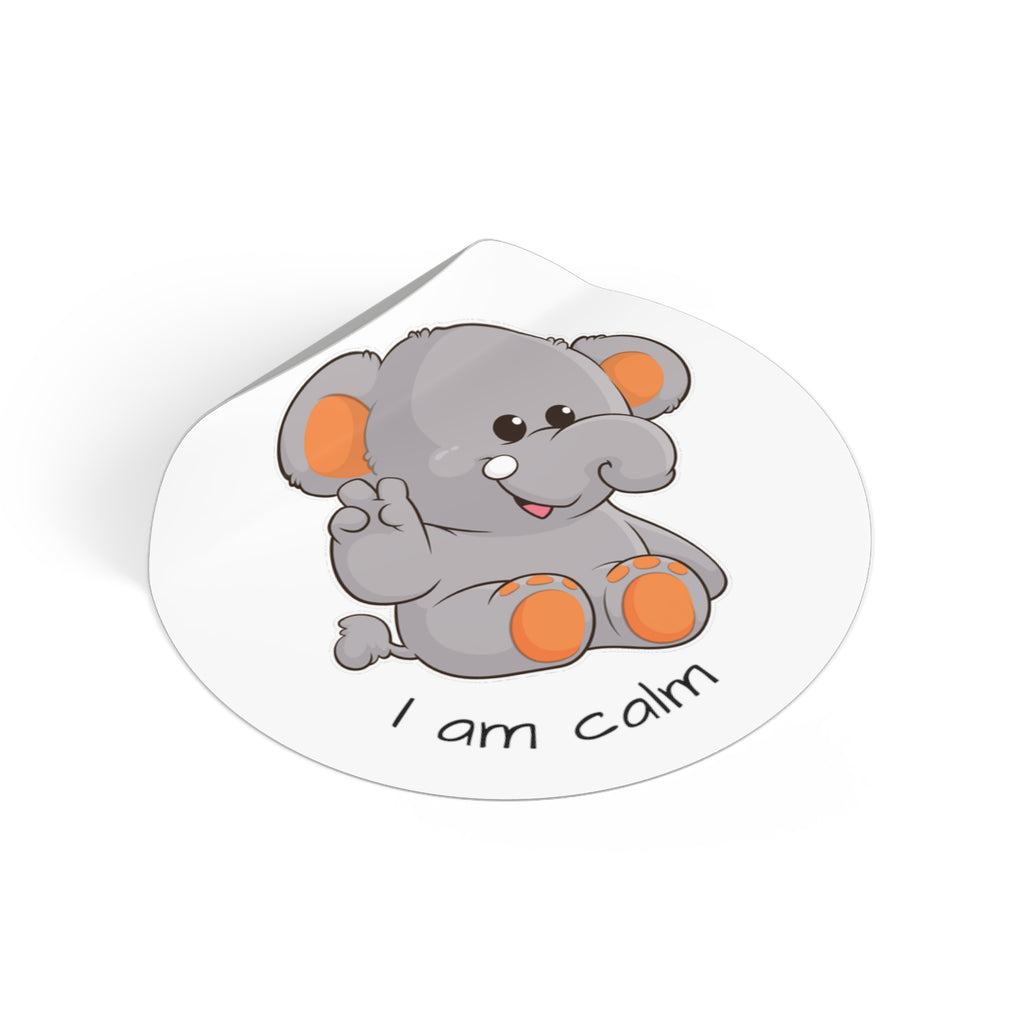 A 2 by 2 inch round white vinyl sticker with a picture of an elephant that says I am calm. The edge of the sticker is curled up.