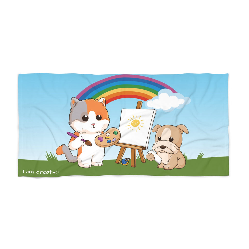 A 36 by 72 inch beach towel with a scene of a cat painting on a canvas next to a dog, a rainbow in the background, and the phrase "I am creative" along the bottom.