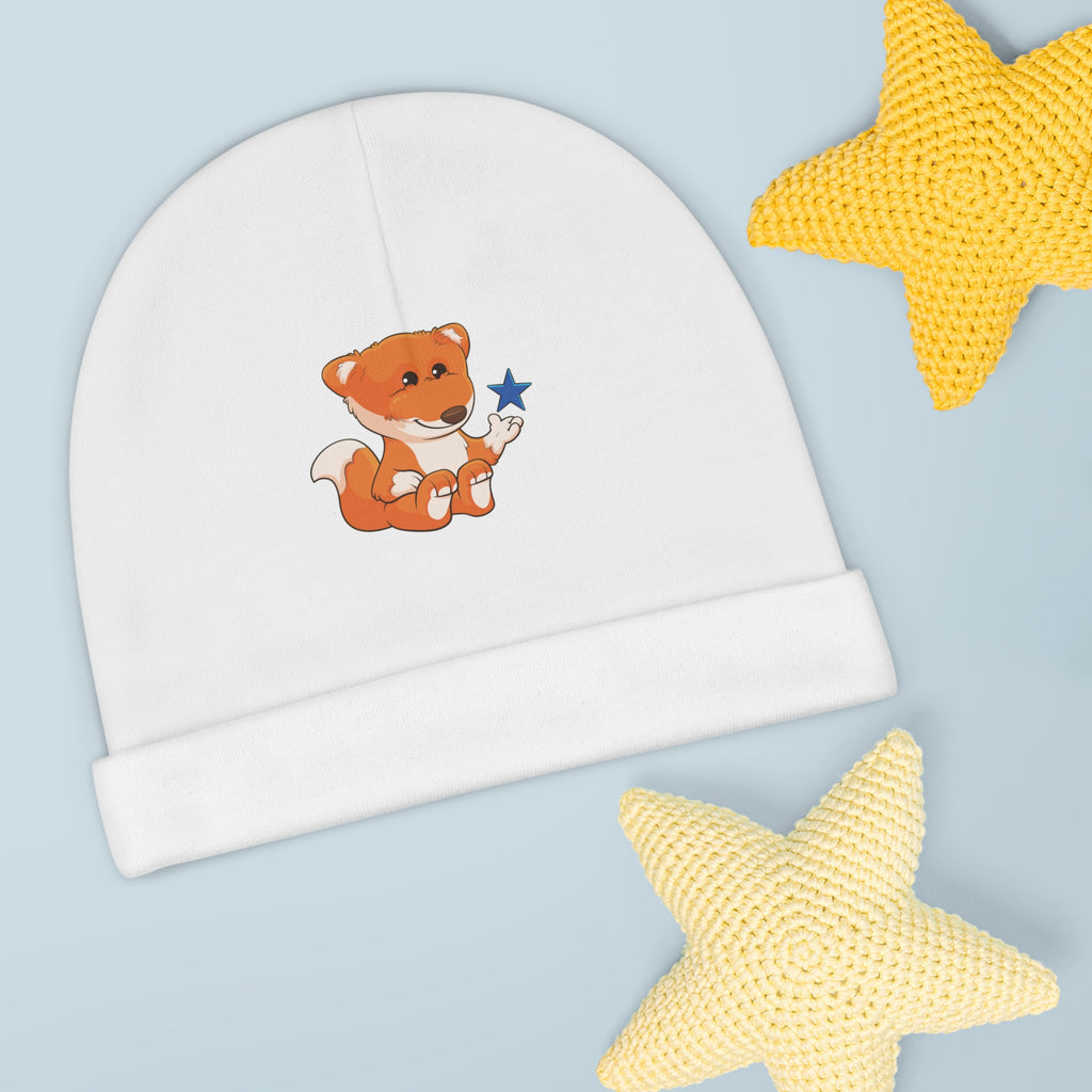 A white baby beanie with a small picture of a fox. The beanie has the bottom edge folded up.