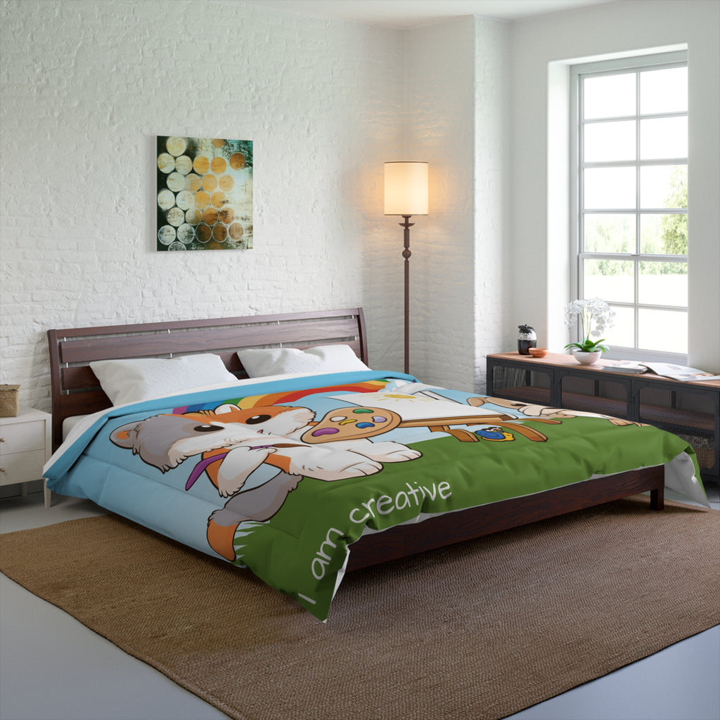 A 104 by 88 inch bed comforter with a scene of a cat painting on a canvas next to a dog, a rainbow in the background, and the phrase "I am creative" along the bottom. The comforter covers a queen-sized bed.