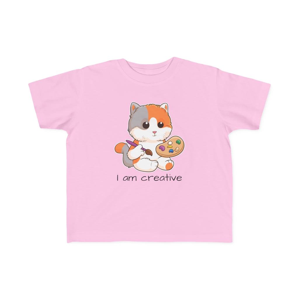 A short-sleeve light pink shirt with a picture of a cat that says I am creative.
