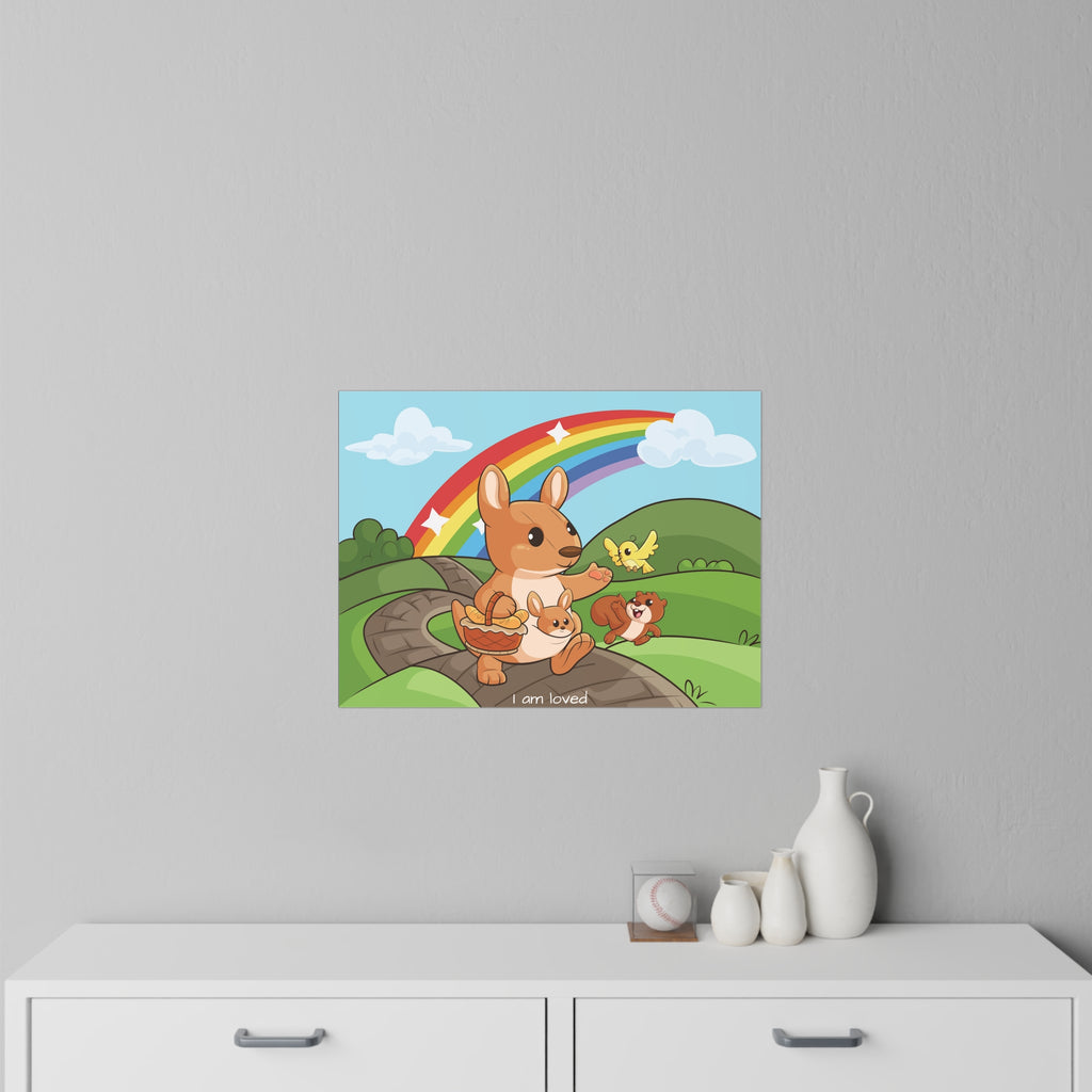 A 24 by 18 inch wall decal on a grey wall above a dresser. The wall decal has a scene of a kangaroo walking along a path through rolling hills, a rainbow in the background, and the phrase "I am loved" along the bottom.