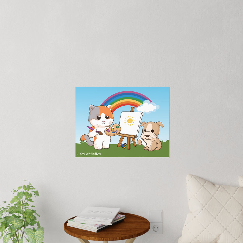 A 24 by 18 inch wall decal on a grey wall above a table and couch. The wall decal has a scene of a cat painting on a canvas next to a dog, a rainbow in the background, and the phrase "I am creative" along the bottom.