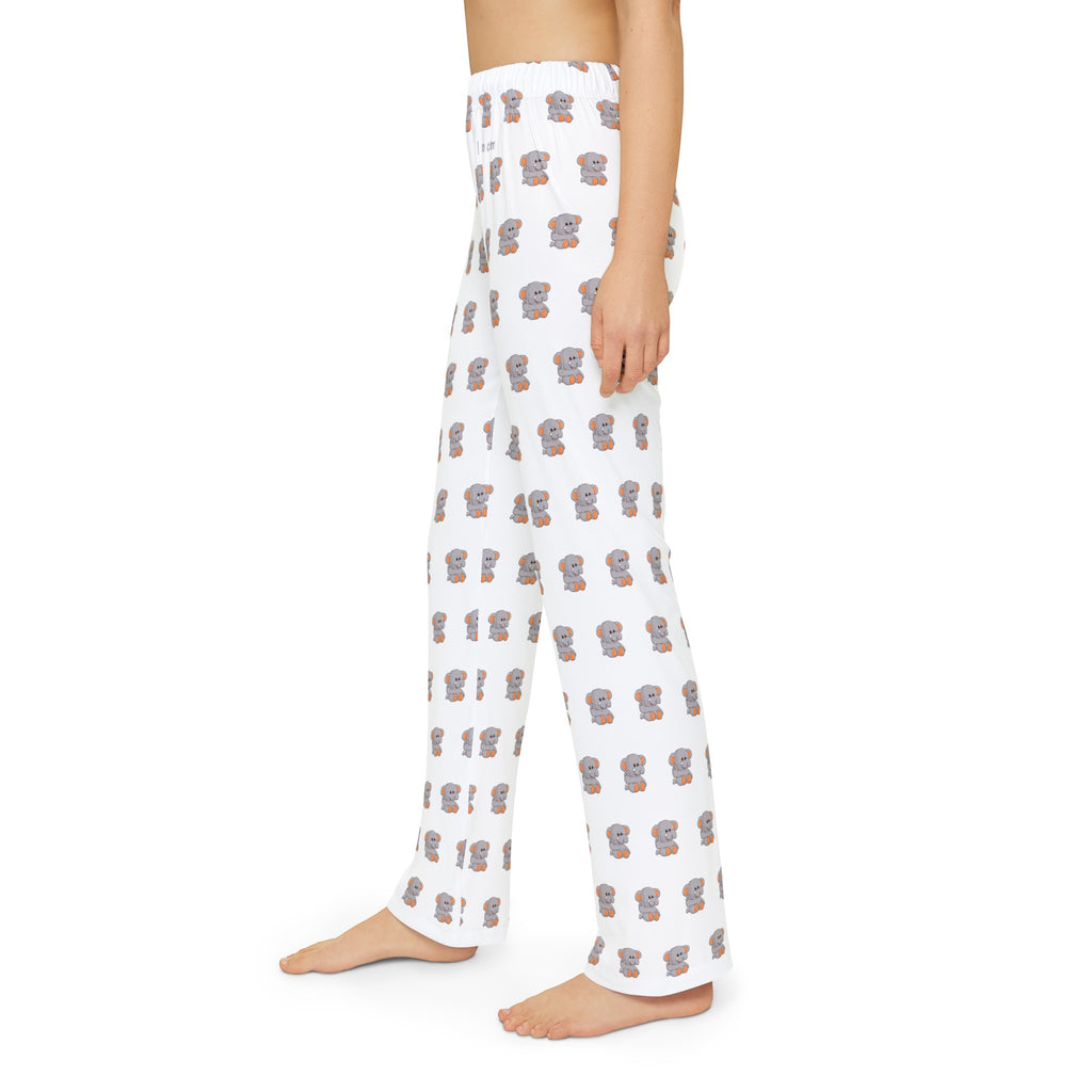 Left side-view of a kid wearing white pajama pants with a repeated pattern of an elephant and the phrase “I am calm” on the front left waist.