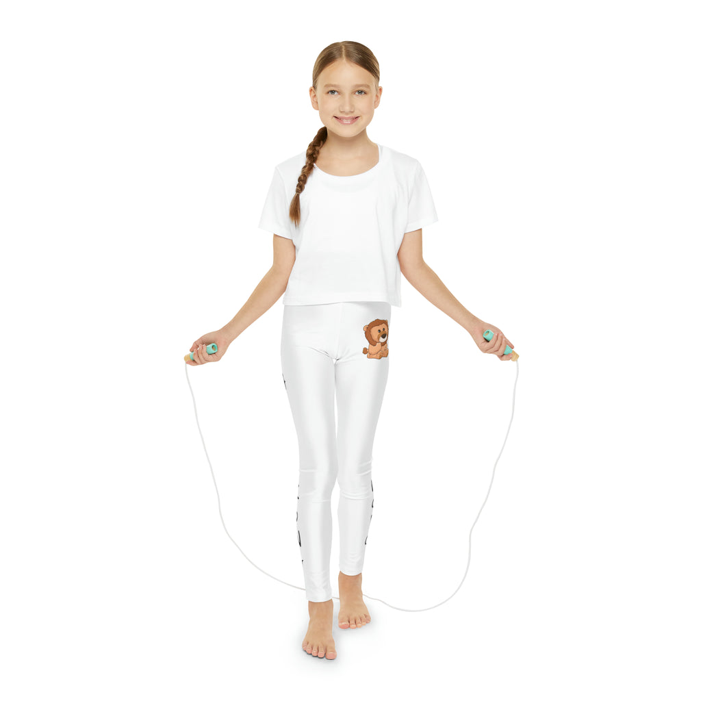 A girl using a jump rope while wearing white leggings with a picture of a lion on the front left waist and the phrase "I am strong" read top to bottom on the side of each leg.