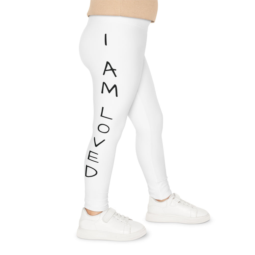 Right side-view of a child wearing white leggings with the phrase "I am loved" read top to bottom on the side of the leg.