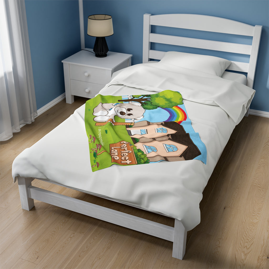A 30 by 40 inch blanket on a twin-sized bed in a bedroom. The blanket has a scene of a bear sitting in the yard of its house with a rainbow in the background and the phrase "I am responsible" along the bottom.