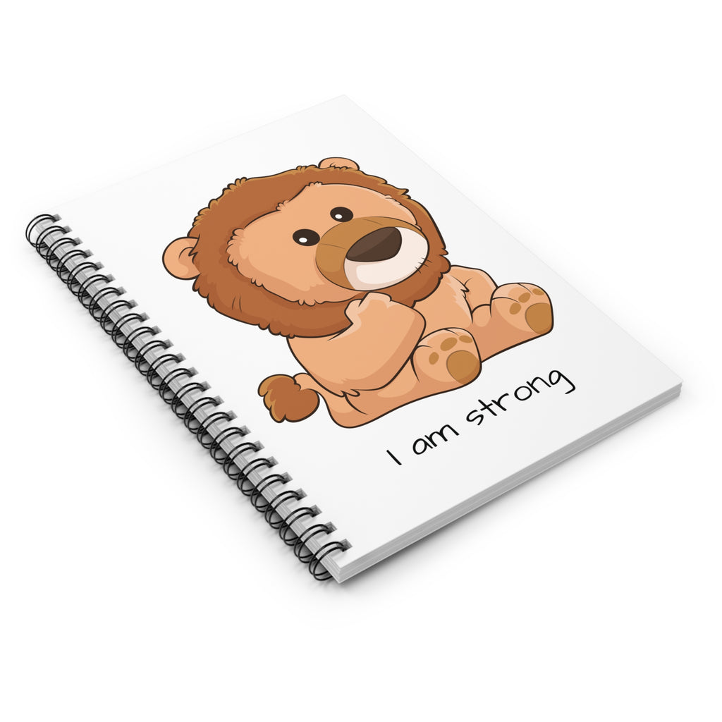 Side-view of a white spiral notebook laying closed, featuring a picture of a lion that says I am strong.