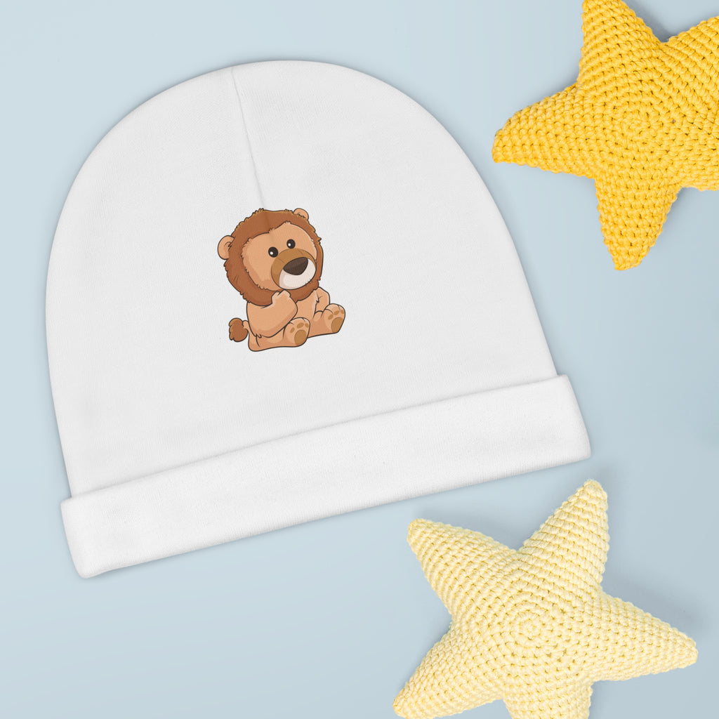 A white baby beanie with a small picture of a lion. The beanie has the bottom edge folded up.