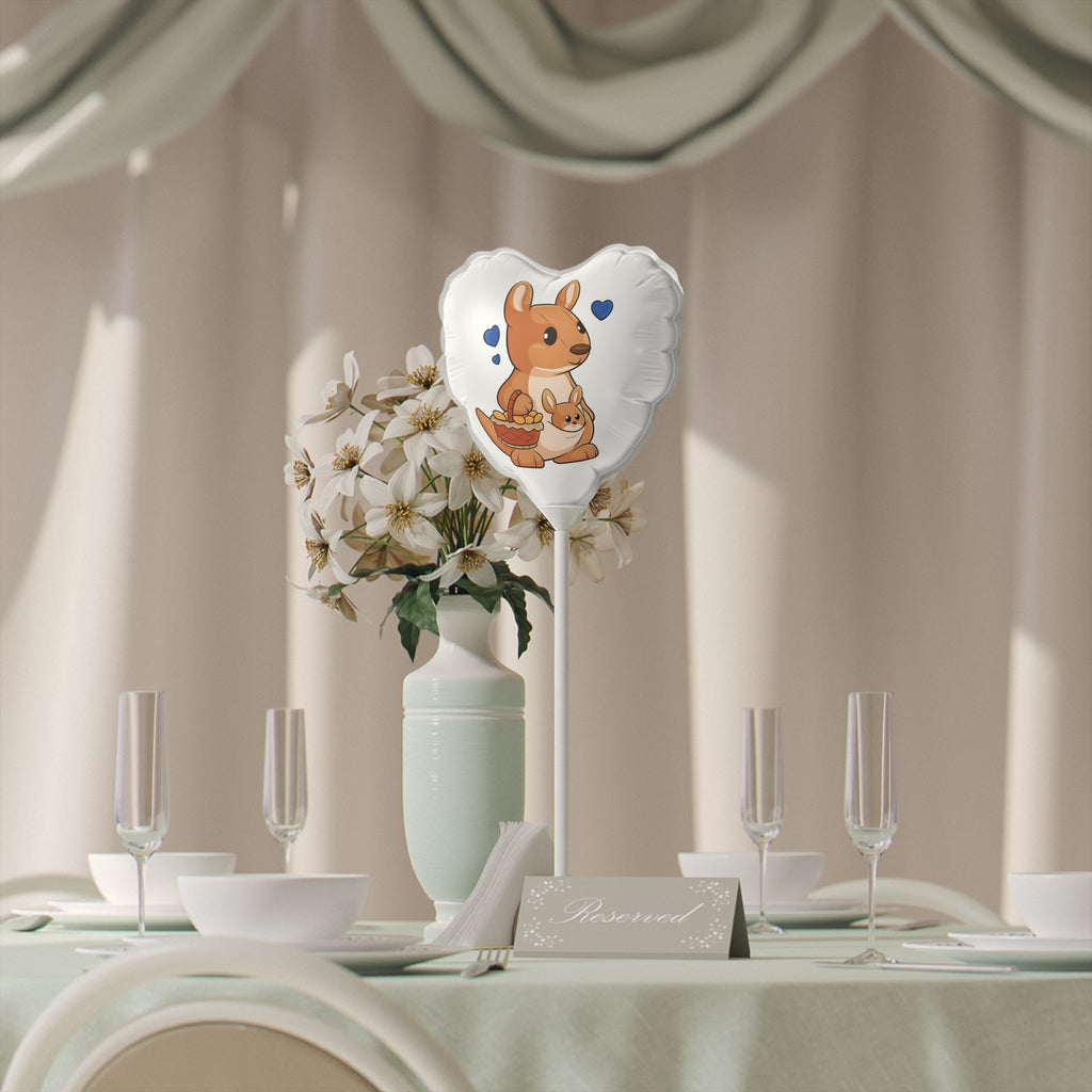 A heart-shaped white mylar balloon on a stick with a picture of a kangaroo. The balloon sits on a table decorated for an event.