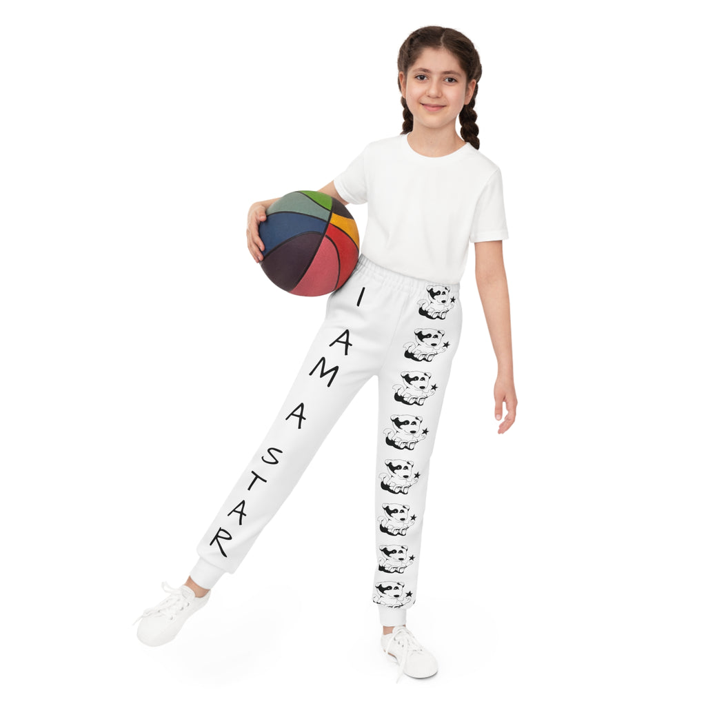 Front-view of a girl holding a basketball and wearing white sweatpants. The pants have a line of black and white foxes down the front left leg and the phrase "I am a star" down the front right leg.