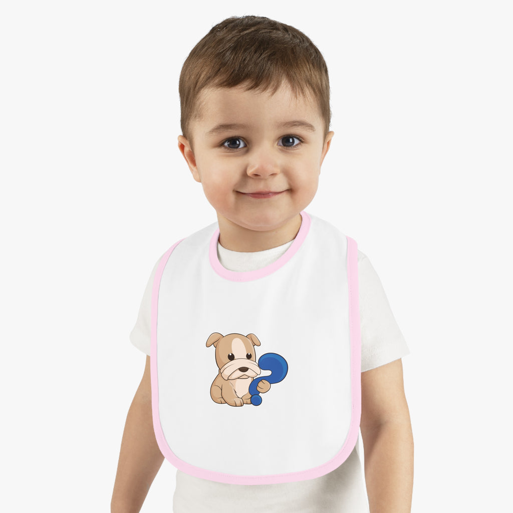 A little boy wearing a white baby bib with light pink trim and a small picture of a dog.