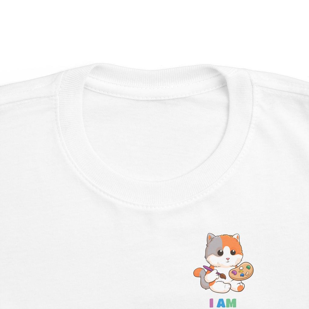 A close-up of the crew neckline of a short-sleeve white shirt with a small picture on the left chest. The image is a cat with a multi-color phrase below it that says I am creative.