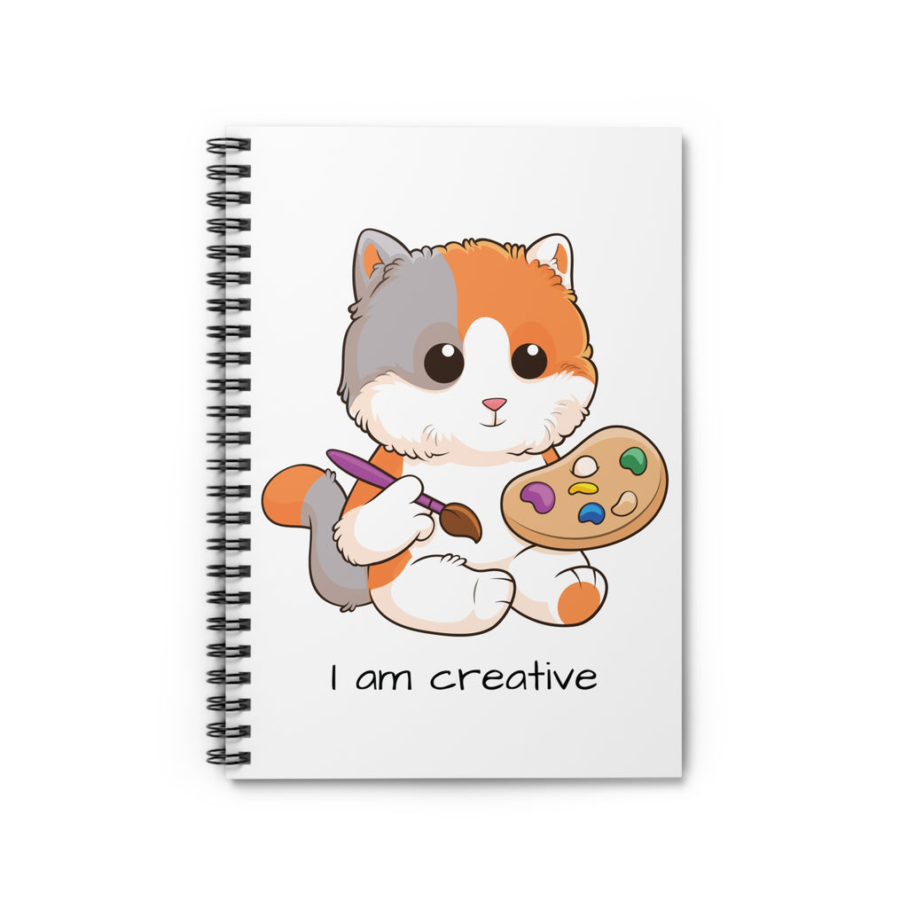 White spiral notebook laying closed, featuring a picture of a cat that says I am creative.