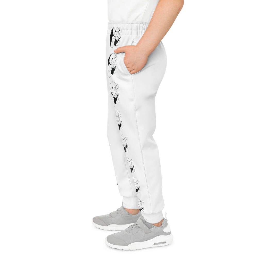 Left side-view of a boy wearing white sweatpants with a line of black and white turtles down the front left leg.