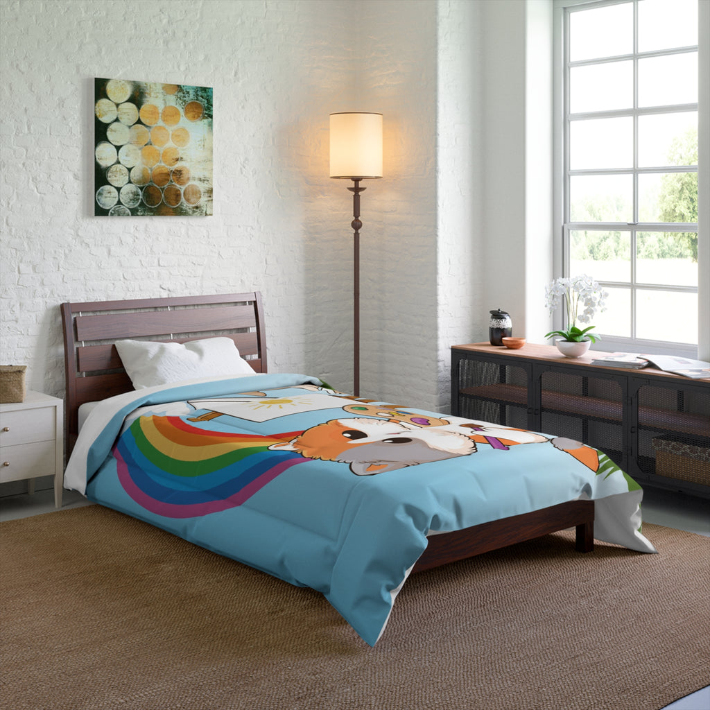 A 68 by 88 inch bed comforter with a scene of a cat painting on a canvas next to a dog, a rainbow in the background, and the phrase "I am creative" along the bottom. The comforter covers a twin-sized bed.