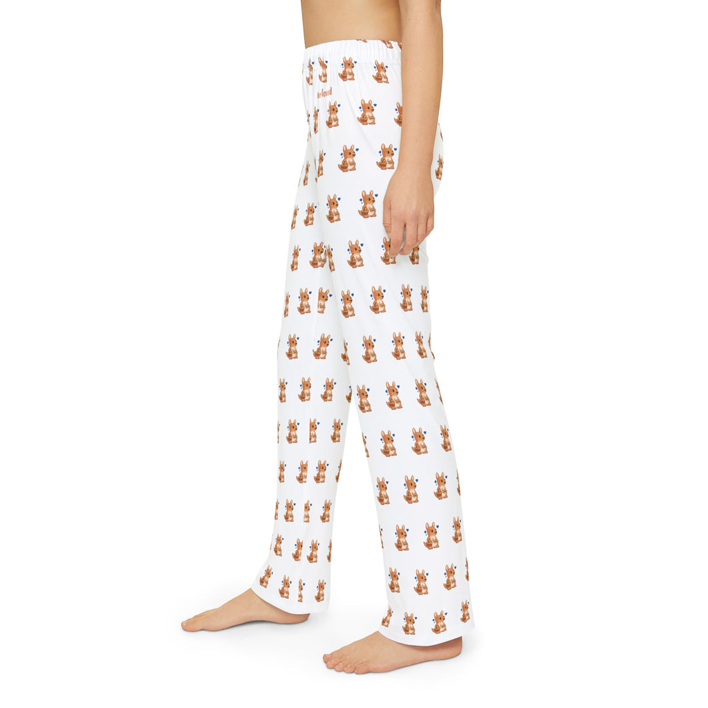 Left side-view of a kid wearing white pajama pants with a repeated pattern of a kangaroo and the phrase “I am loved” on the front left waist.