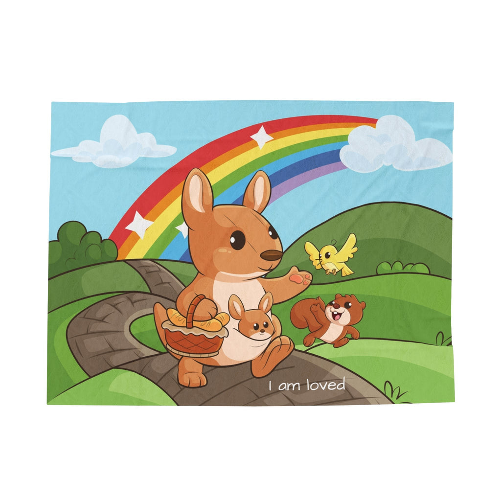 A blanket that has a scene of a kangaroo walking along a path through rolling hills, a rainbow in the background, and the phrase "I am loved" along the bottom.