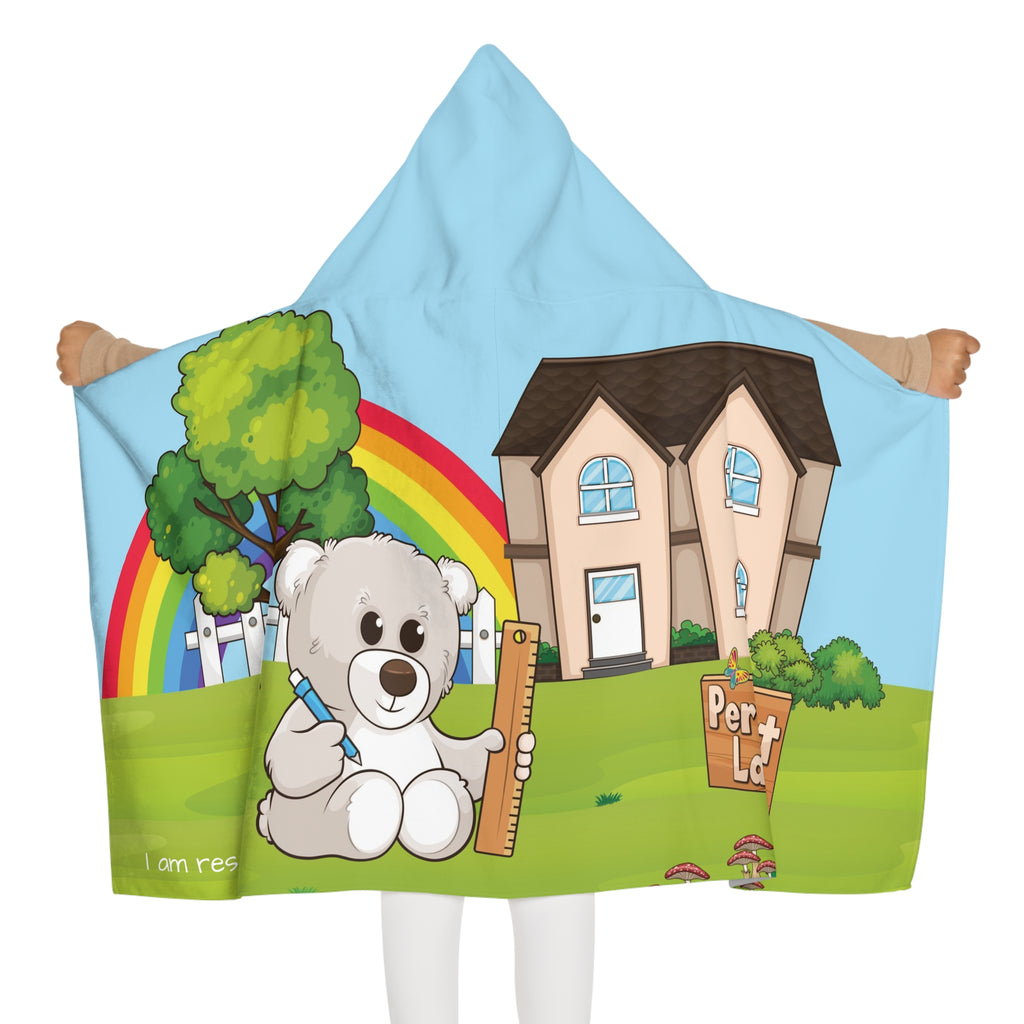 Back-view of a girl wearing a hooded towel and holding it open. The towel has a scene of a bear sitting in the yard of its house, a rainbow in the background, and the phrase "I am responsible" along the bottom.