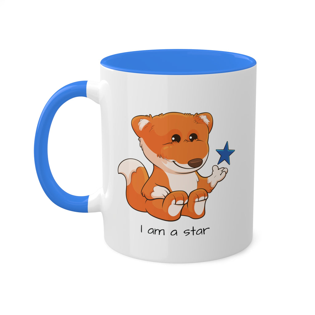 A white mug with a cambridge blue handle and interior and a picture of a fox that says I am a star.
