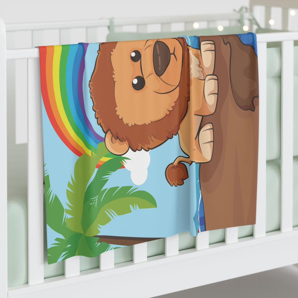 Full-color swaddle blanket with a lion standing on a cliff over the ocean with a rainbow in the background. The blanket is draped over the side of a baby crib.