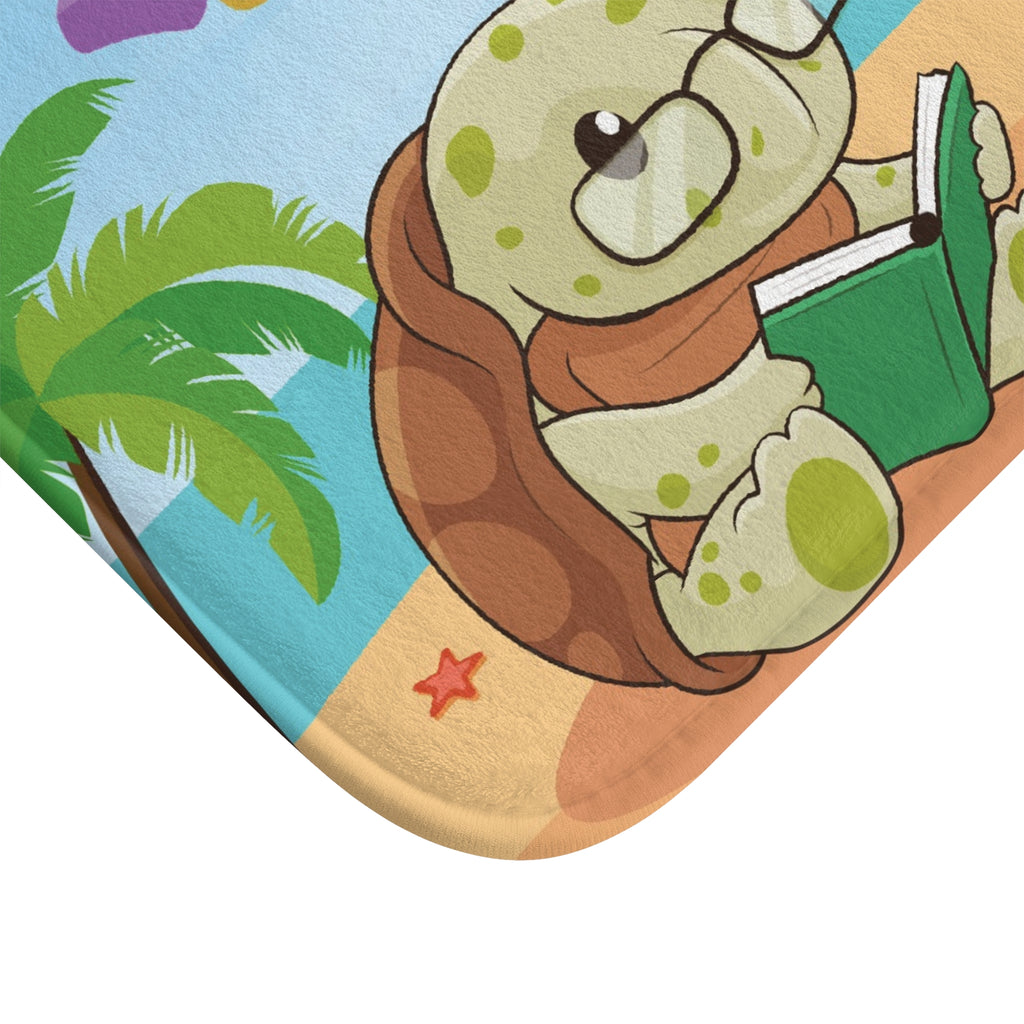 A close-up of the corner of the bath mat with a scene of a turtle reading on a beach.