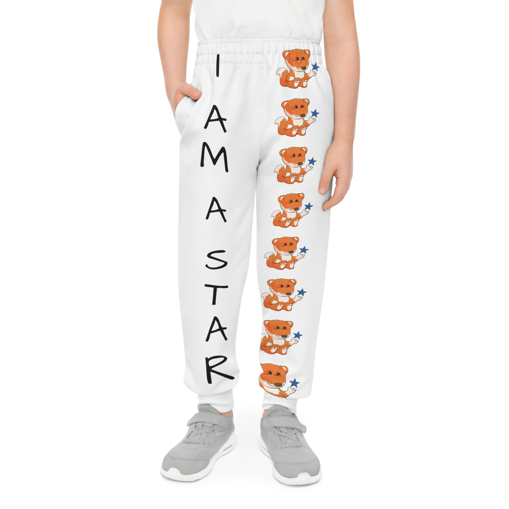 Front-view of a boy wearing white sweatpants with a line of foxes down the front left leg and the phrase "I am a star" down the front right leg.