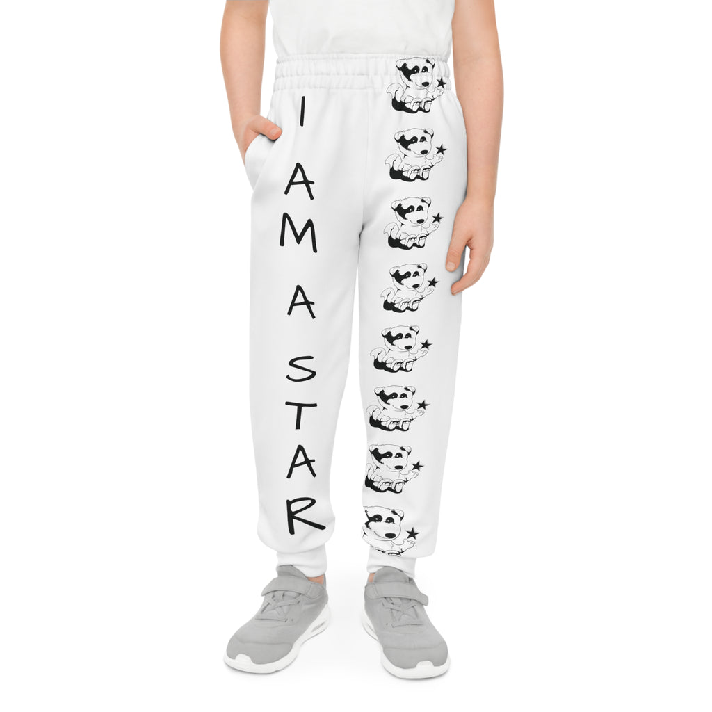 Front-view of a boy wearing white sweatpants with a line of black and white foxes down the front left leg and the phrase "I am a star" down the front right leg.