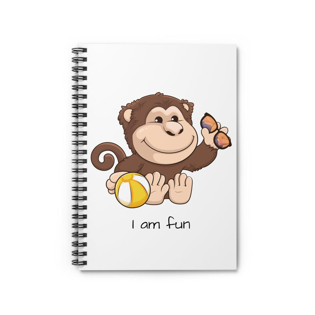 White spiral notebook laying closed, featuring a picture of a monkey that says I am fun.