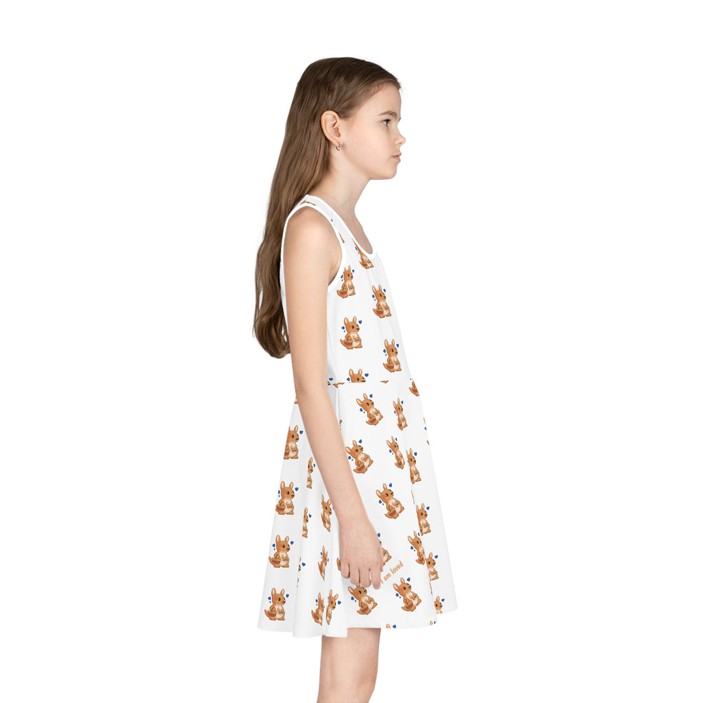 Right side-view of a girl wearing a sleeveless white dress with a repeating pattern of a kangaroo.