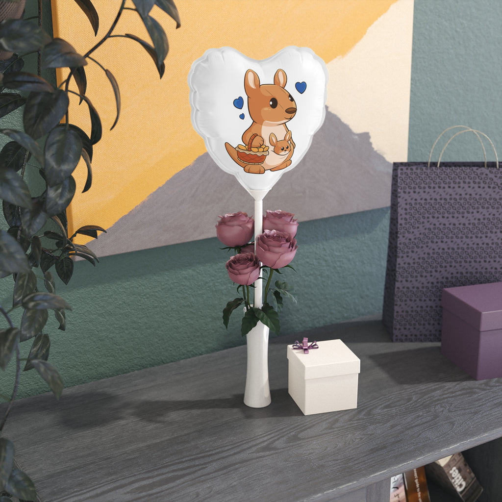 A heart-shaped white mylar balloon on a stick with a picture of a kangaroo. The balloon sits in a flower vase on a gift table.
