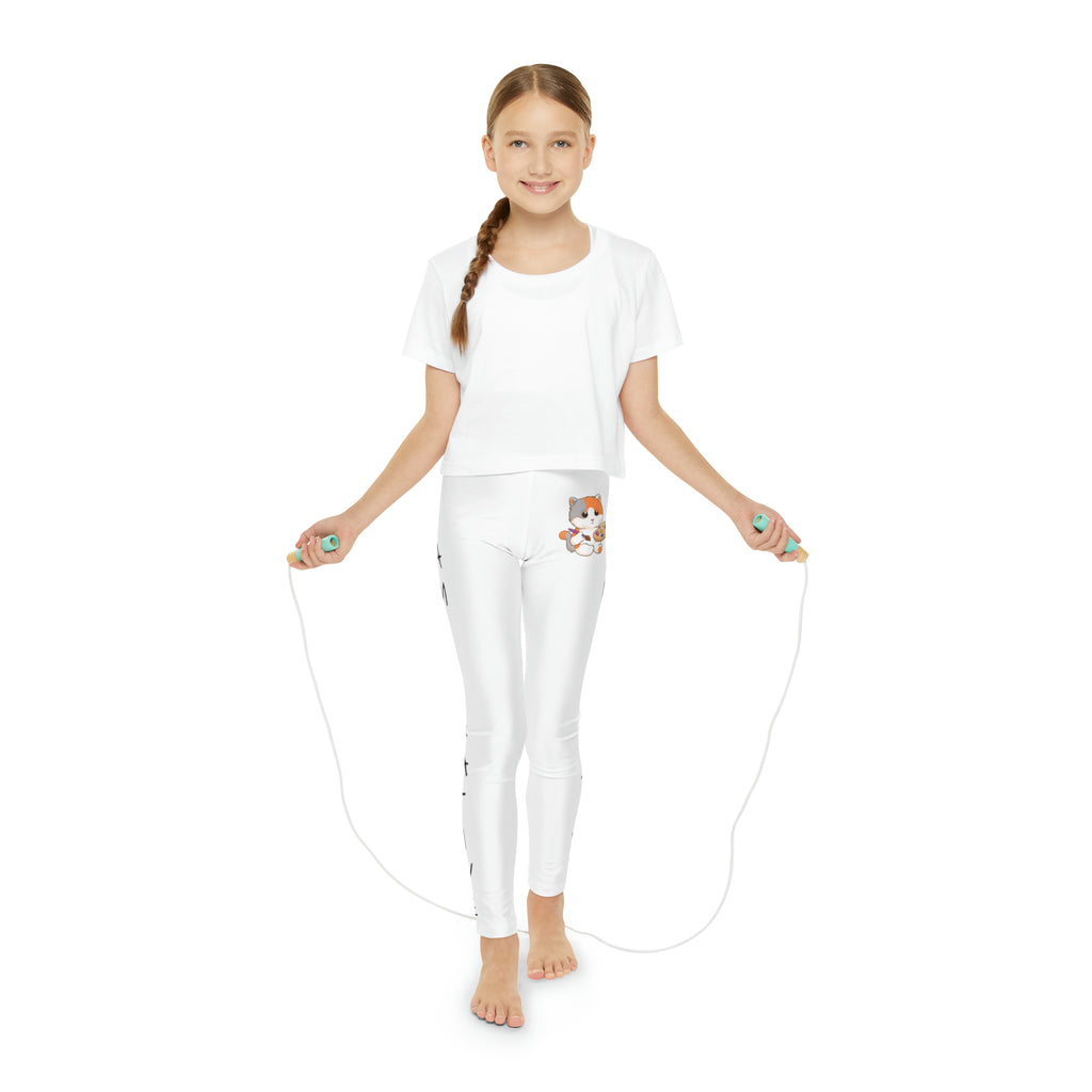 A girl using a jump rope while wearing white leggings with a picture of a cat on the front left waist and the phrase "I am creative" read top to bottom on the side of each leg.