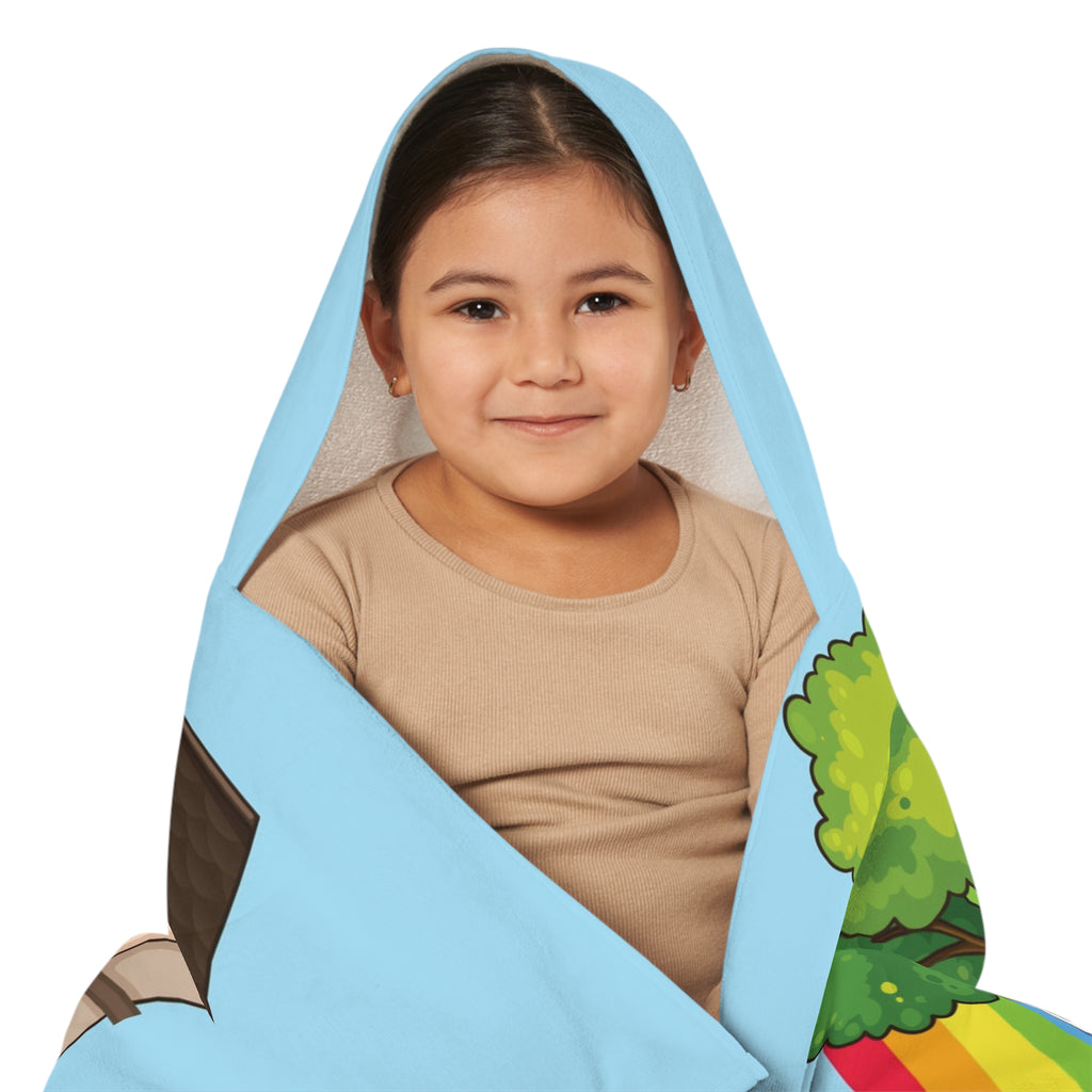 Close-up of a girl wearing a hooded towel and holding it closed around her. The towel has a scene of a bear sitting in the yard of its house, a rainbow in the background, and the phrase "I am responsible" along the bottom.