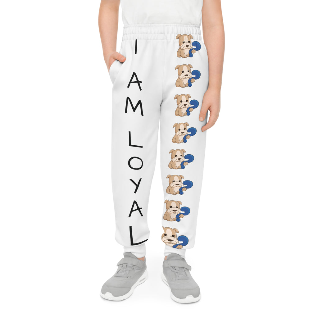Front-view of a boy wearing white sweatpants with a line of dogs down the front left leg and the phrase "I am loyal" down the front right leg.